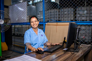 Woman working at a desk in a factory.