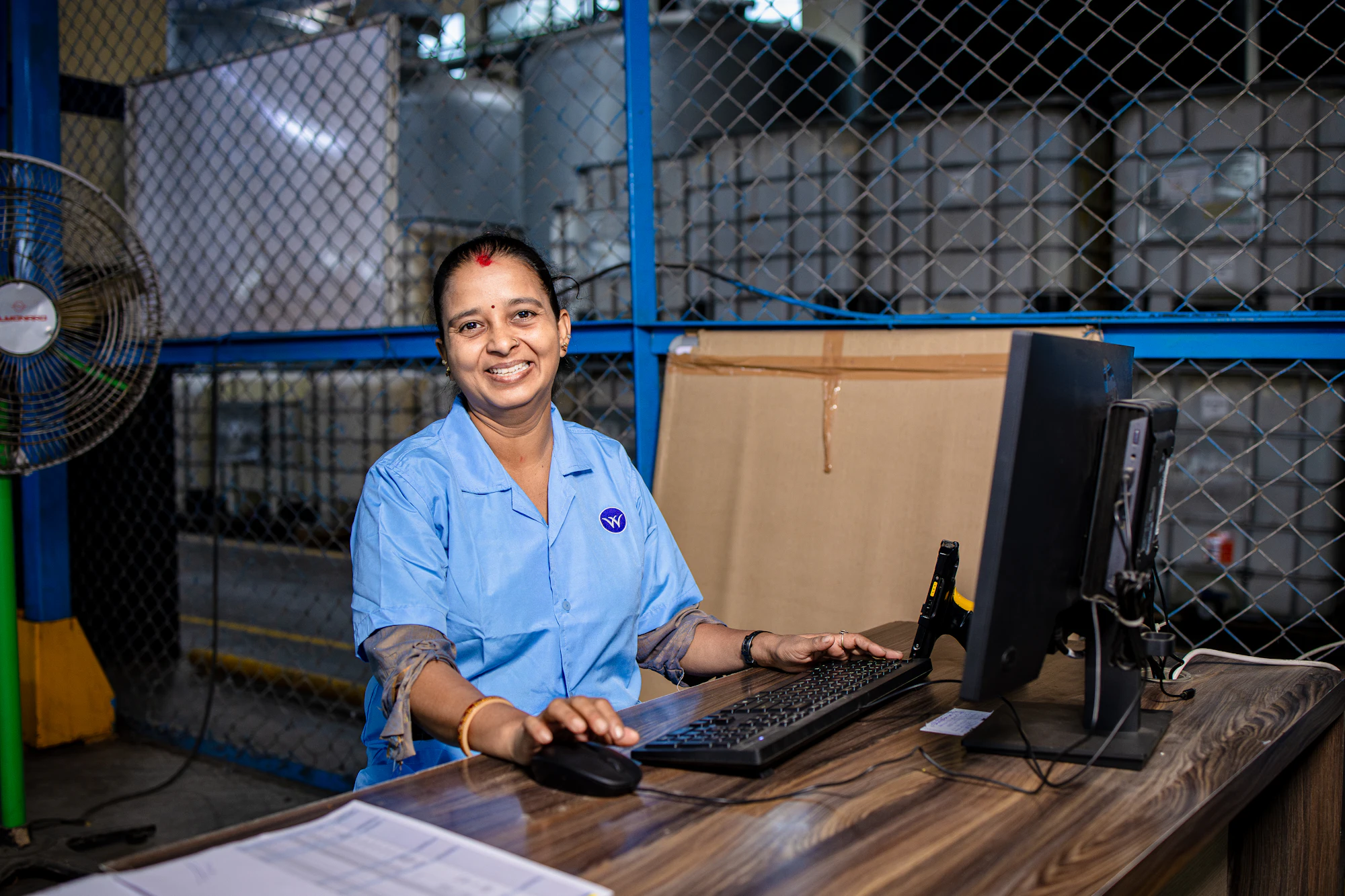 An operator working at a desk on a production floor