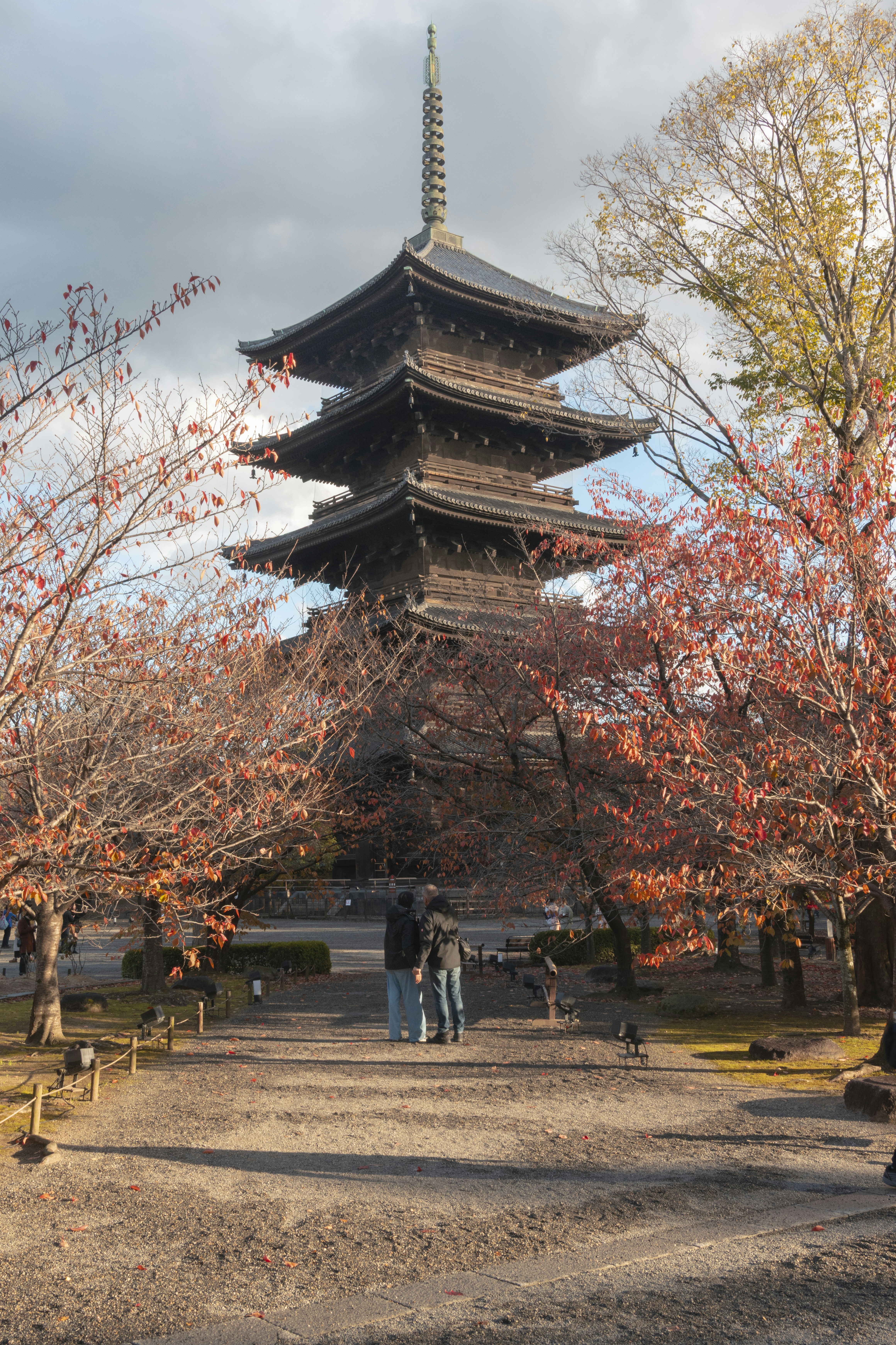 A tall japanese pagoda stands between trees.