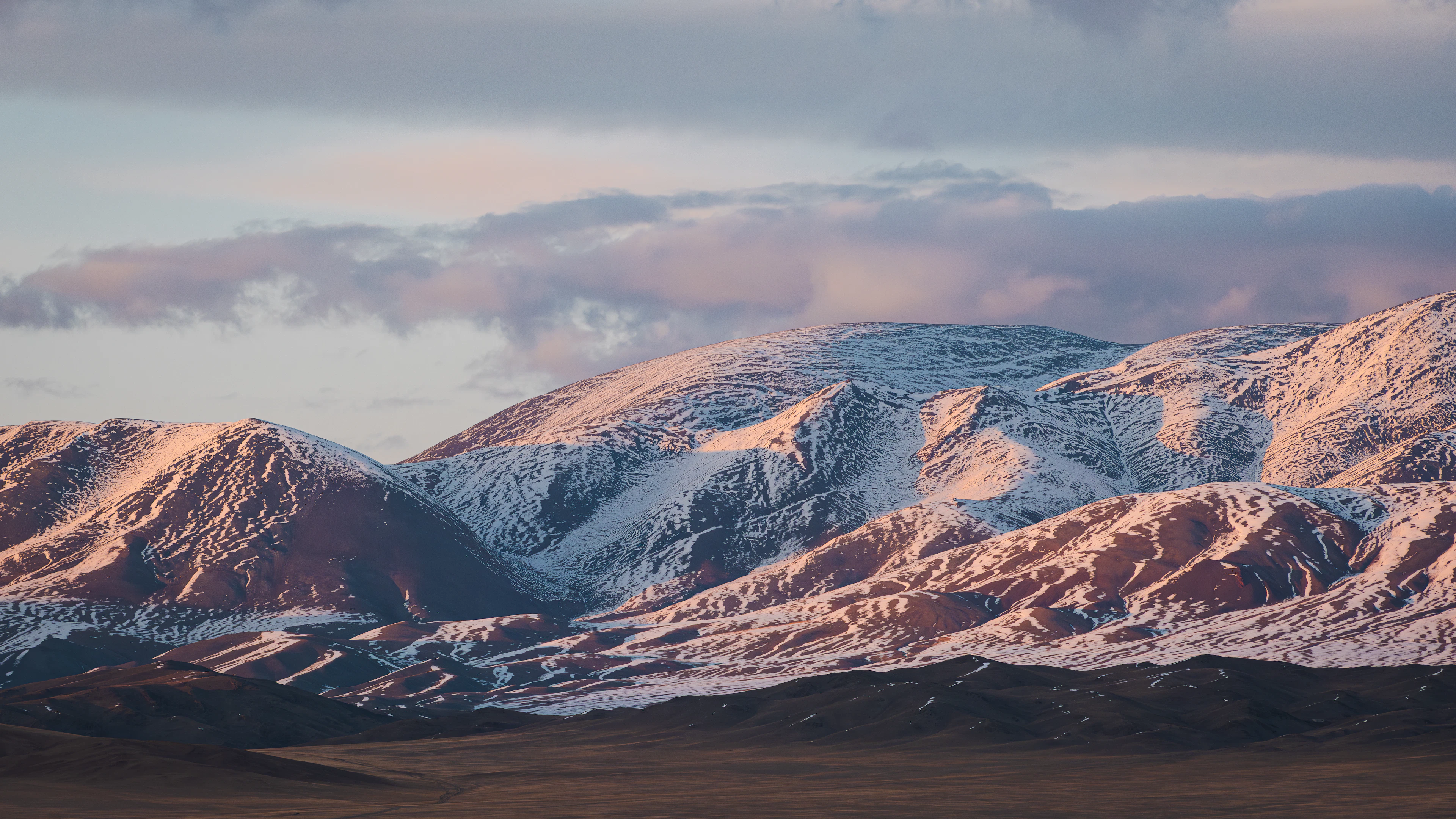 Snowy mountains turning pink in evening light