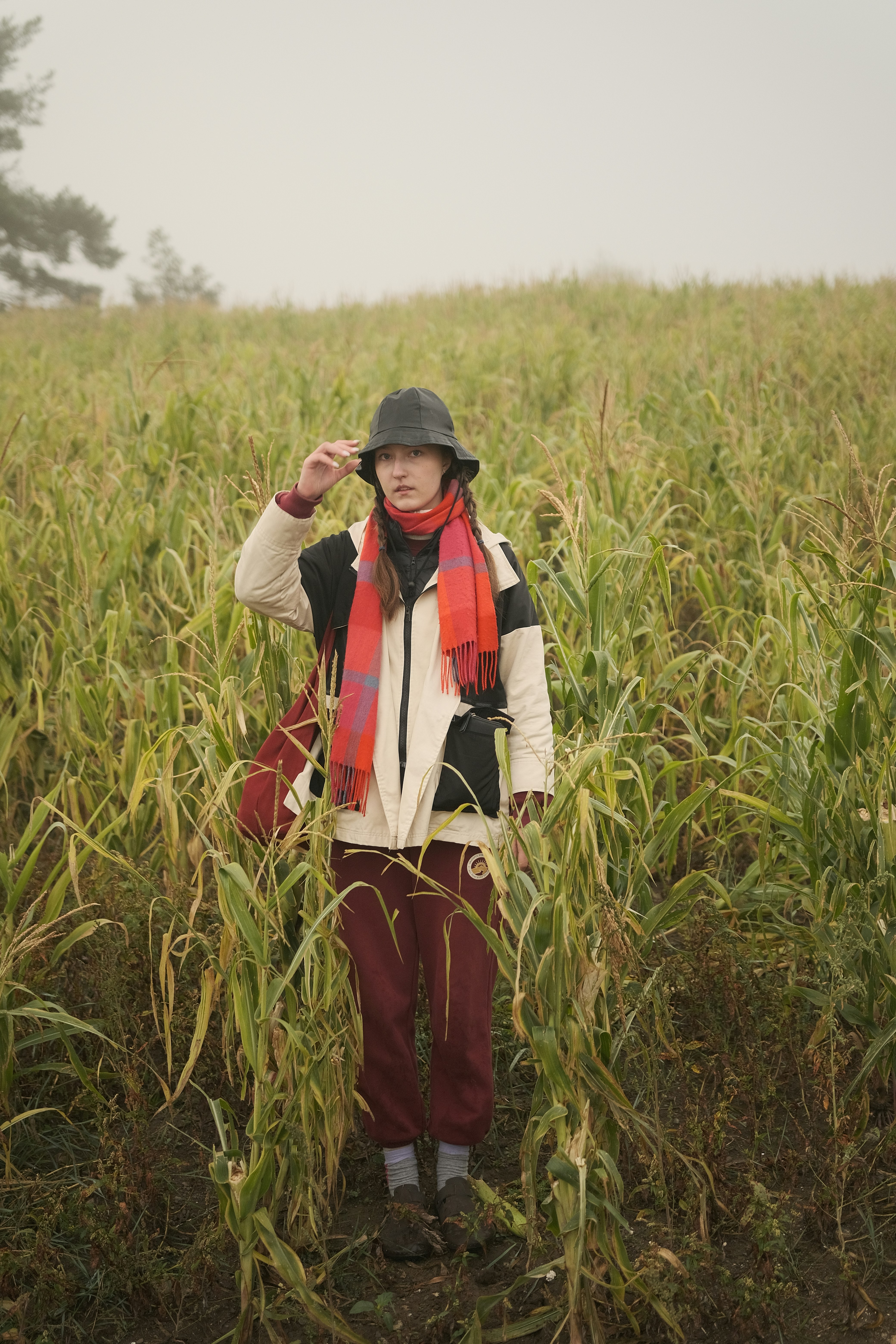 Woman stands in a field of tall grass.