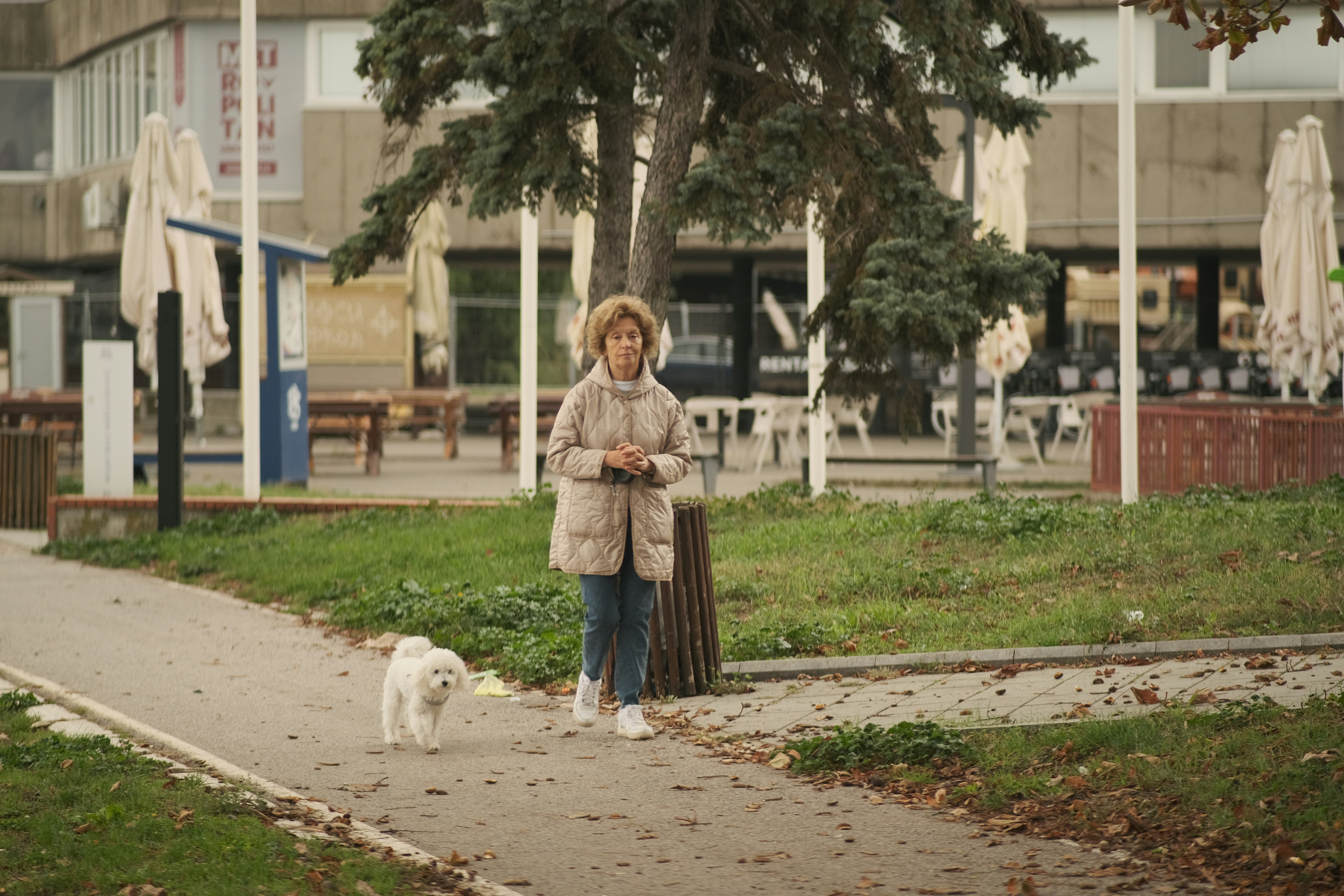 Woman walks her dog in a park.