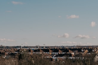 Houses under a blue sky with scattered clouds.