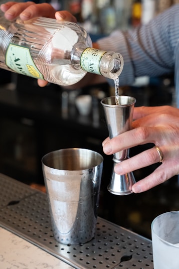 Bartender pouring liquor into a jigger.
