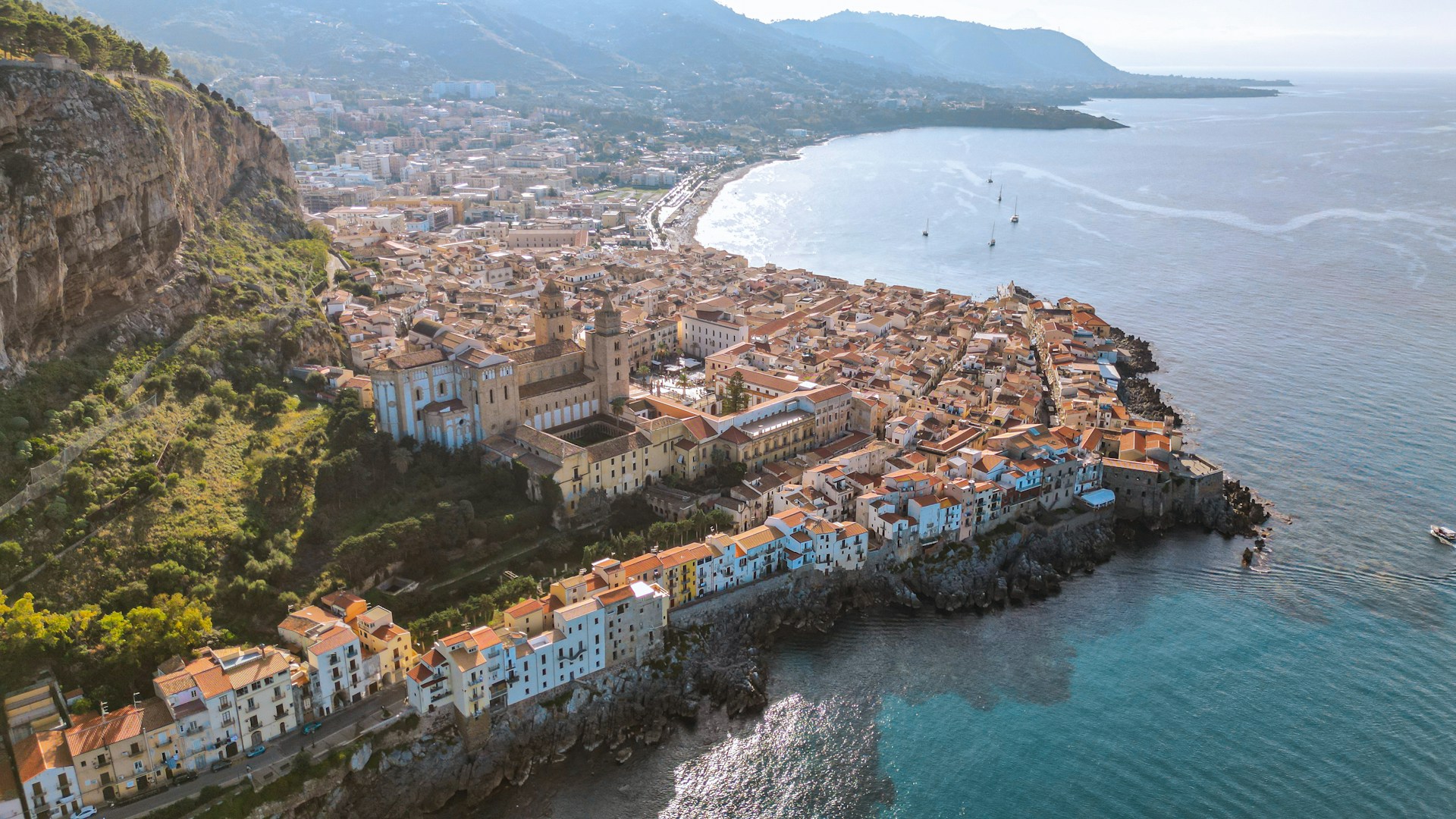 Coastal town sits nestled against mountains and sea.