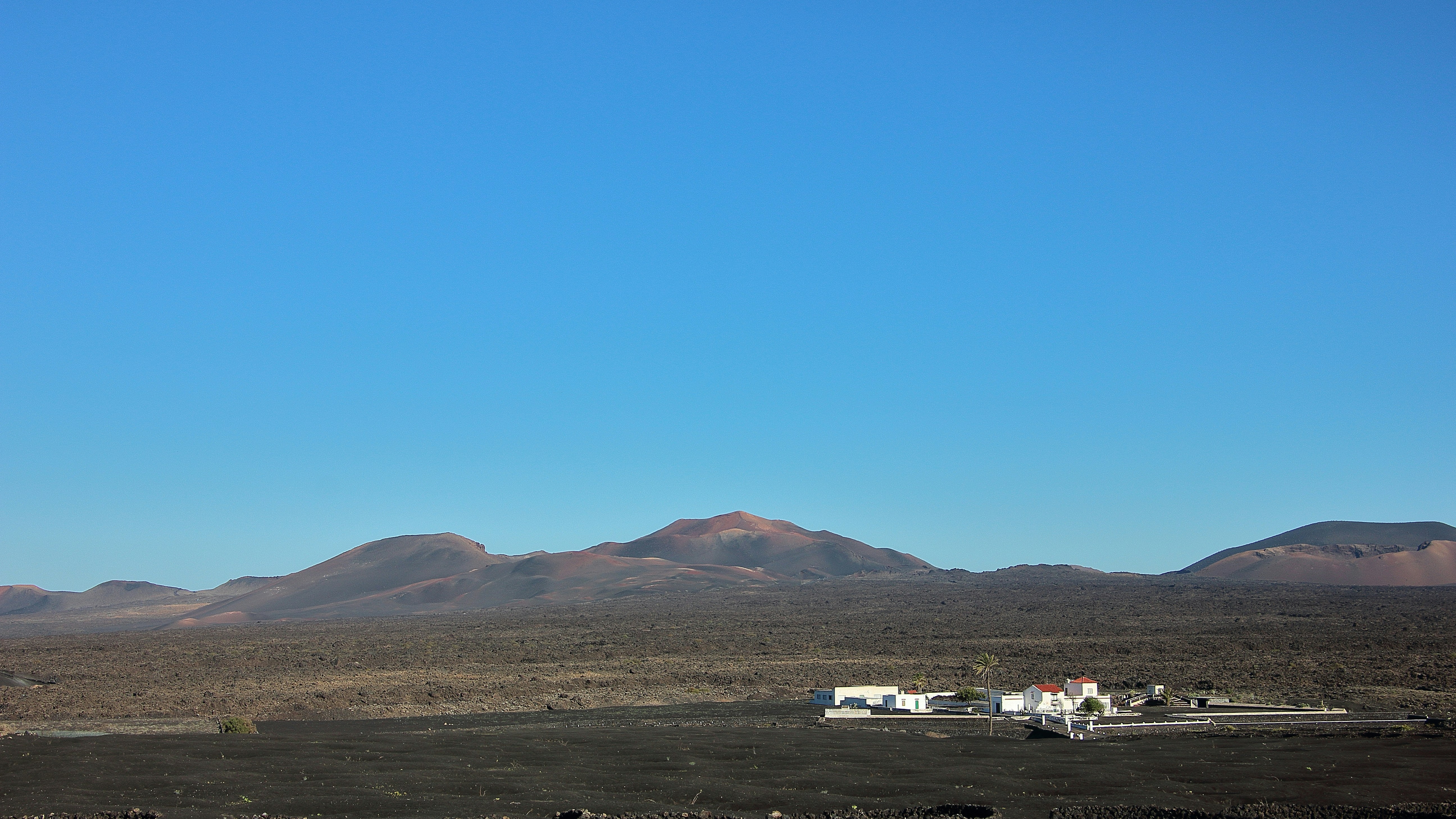 Berge und ein Gebäude unter blauem Himmel.