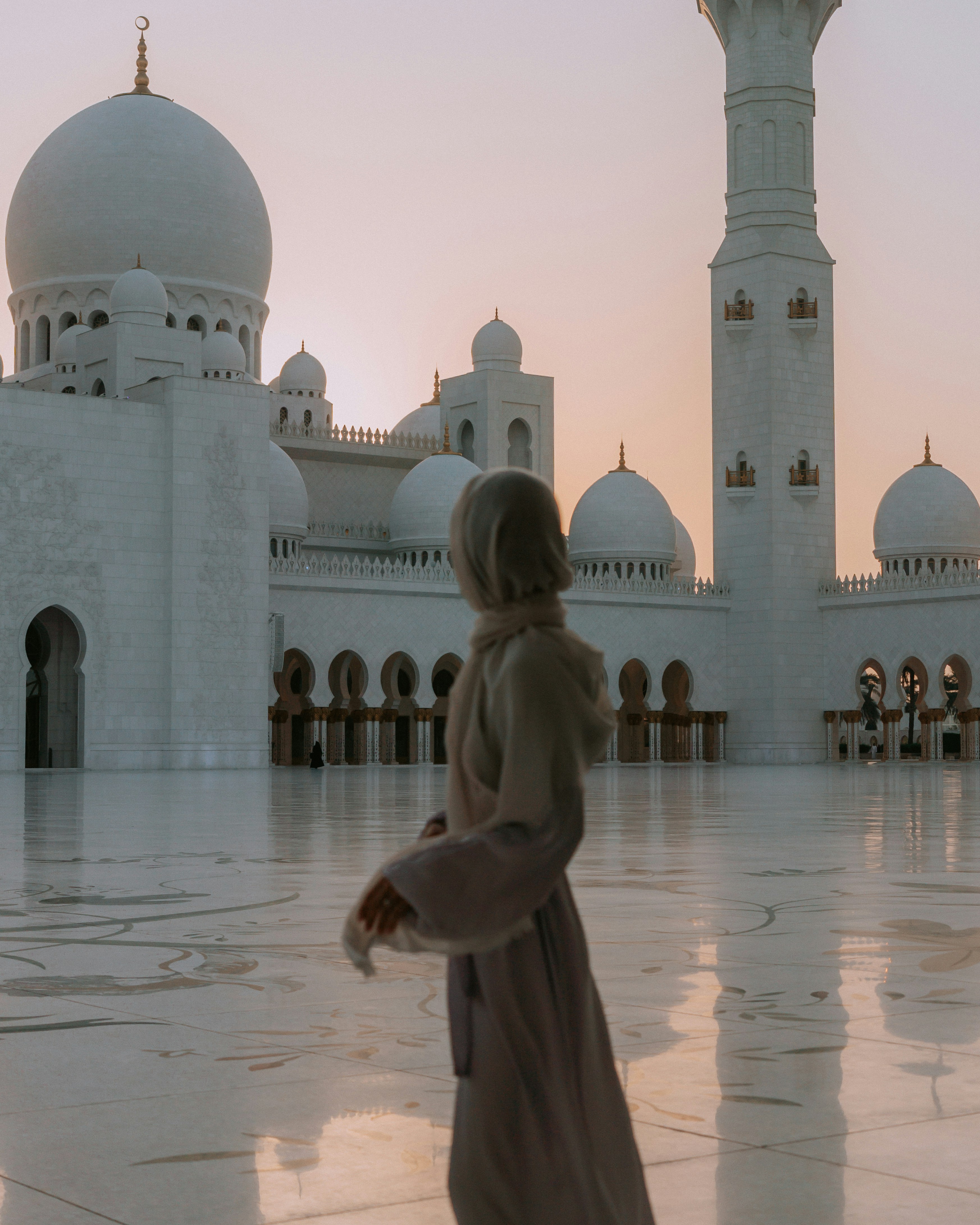 Woman at mosque during golden hour.