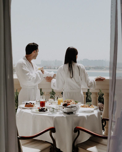 Couple enjoys breakfast on a balcony with a view.