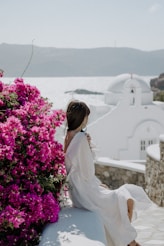 Woman enjoys scenic view near flowers and architecture.