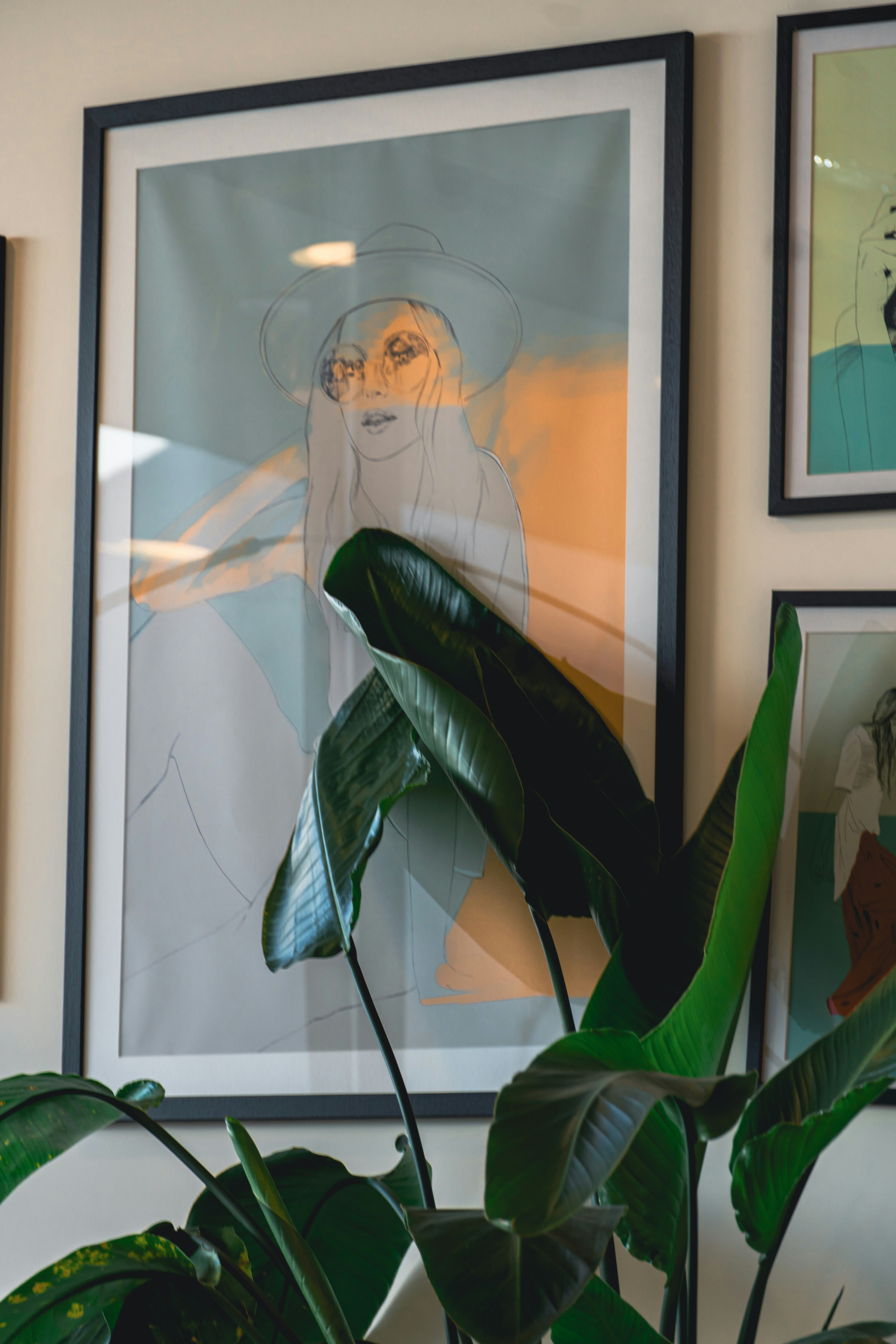 An art print of a woman with a hat.