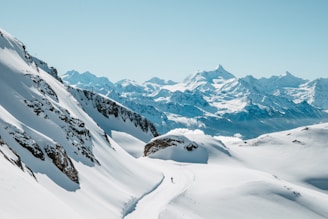Snow-covered mountains under a clear, bright sky.