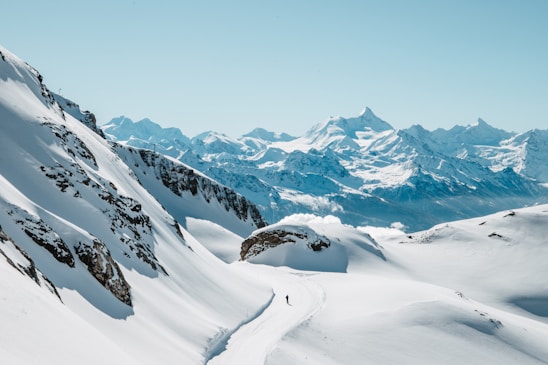 Snow-covered mountains under a clear, bright sky.