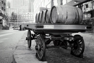 A wagon carries barrels down a city street.