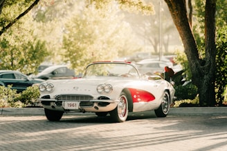 A classic white corvette convertible sits outdoors.