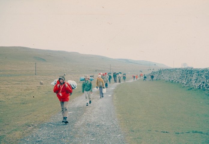 Hikers walk along a path in a rural area.
