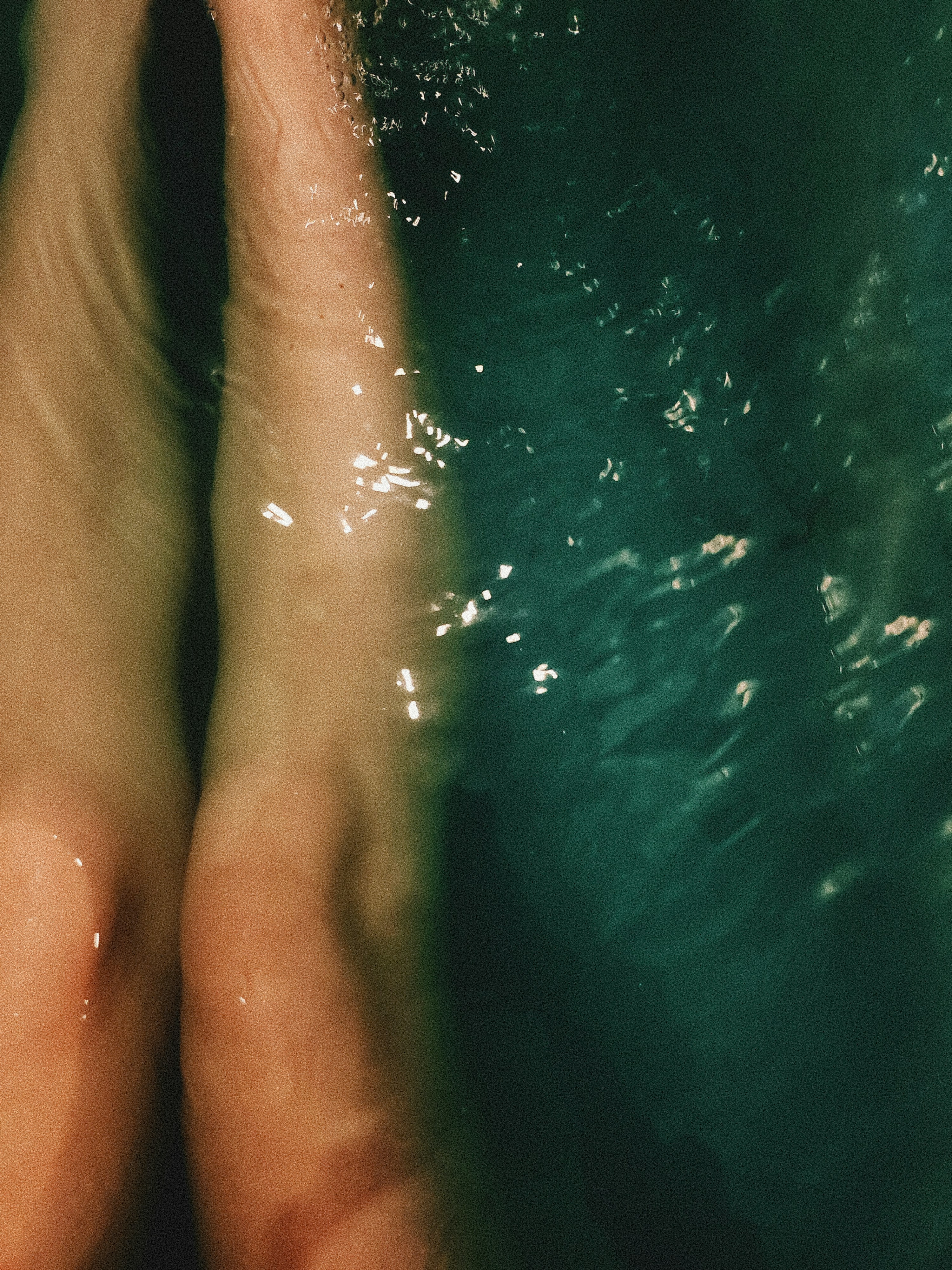 Legs submerged in dark water, with bubbles.