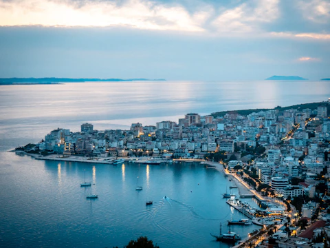 City lights illuminate a scenic waterfront at dusk