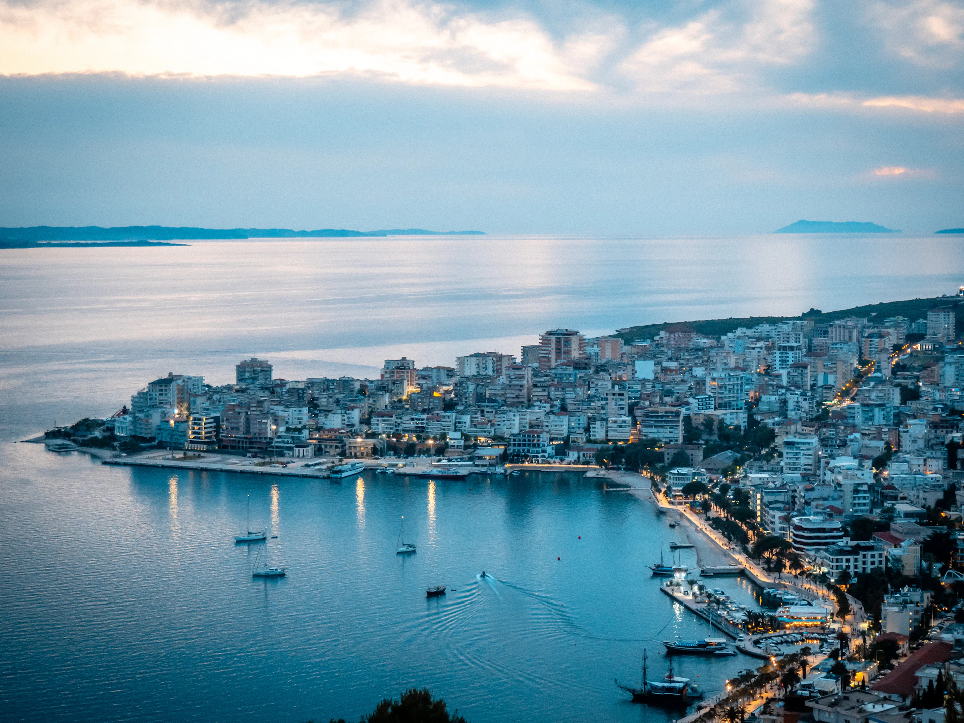 City lights illuminate a scenic waterfront at dusk