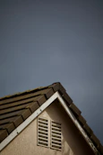 House roof corner against a cloudy sky.