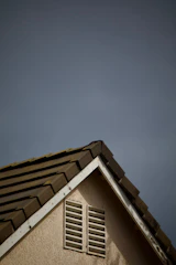 House roof corner against a cloudy sky.