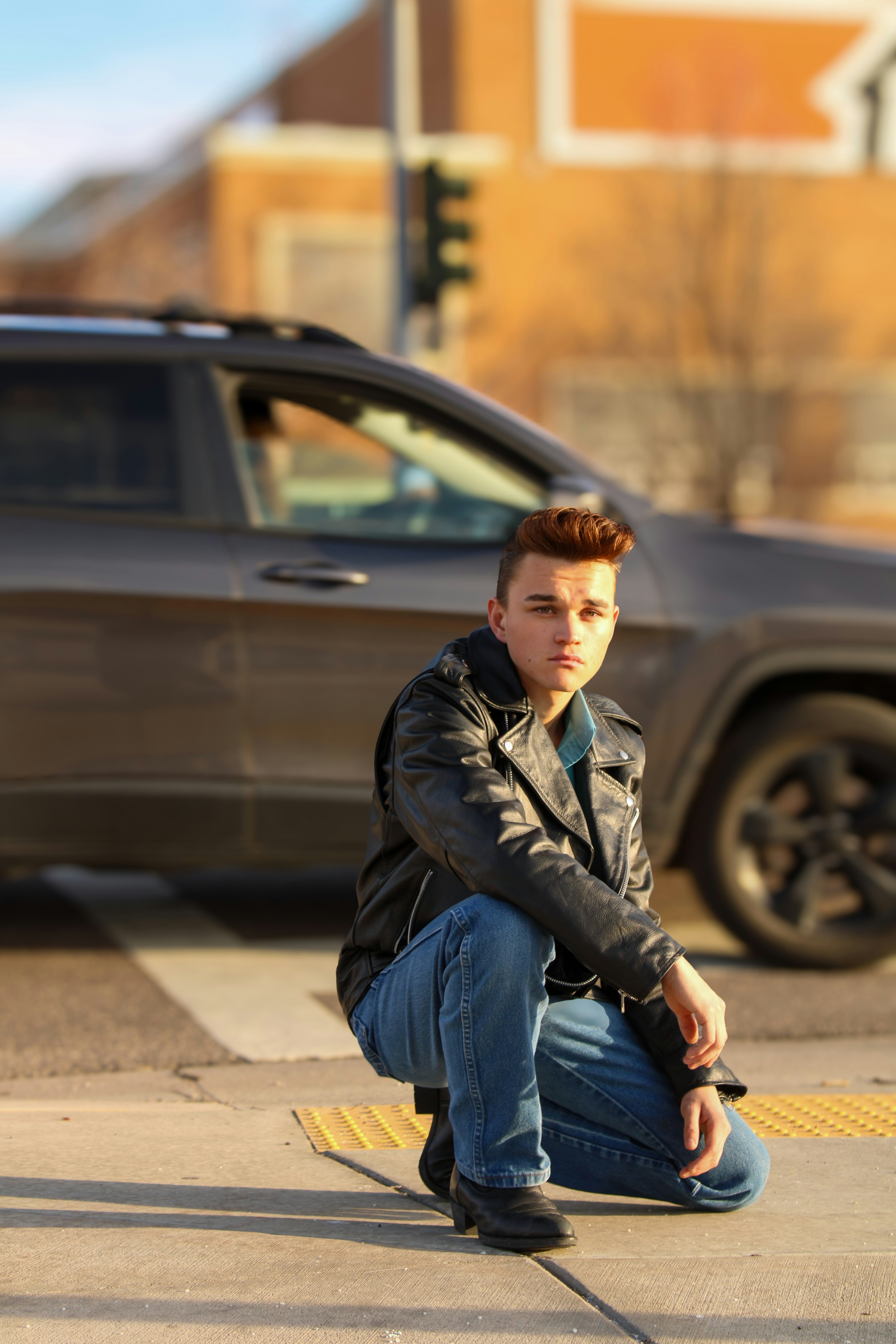 車のそばでポーズをとる若い男性