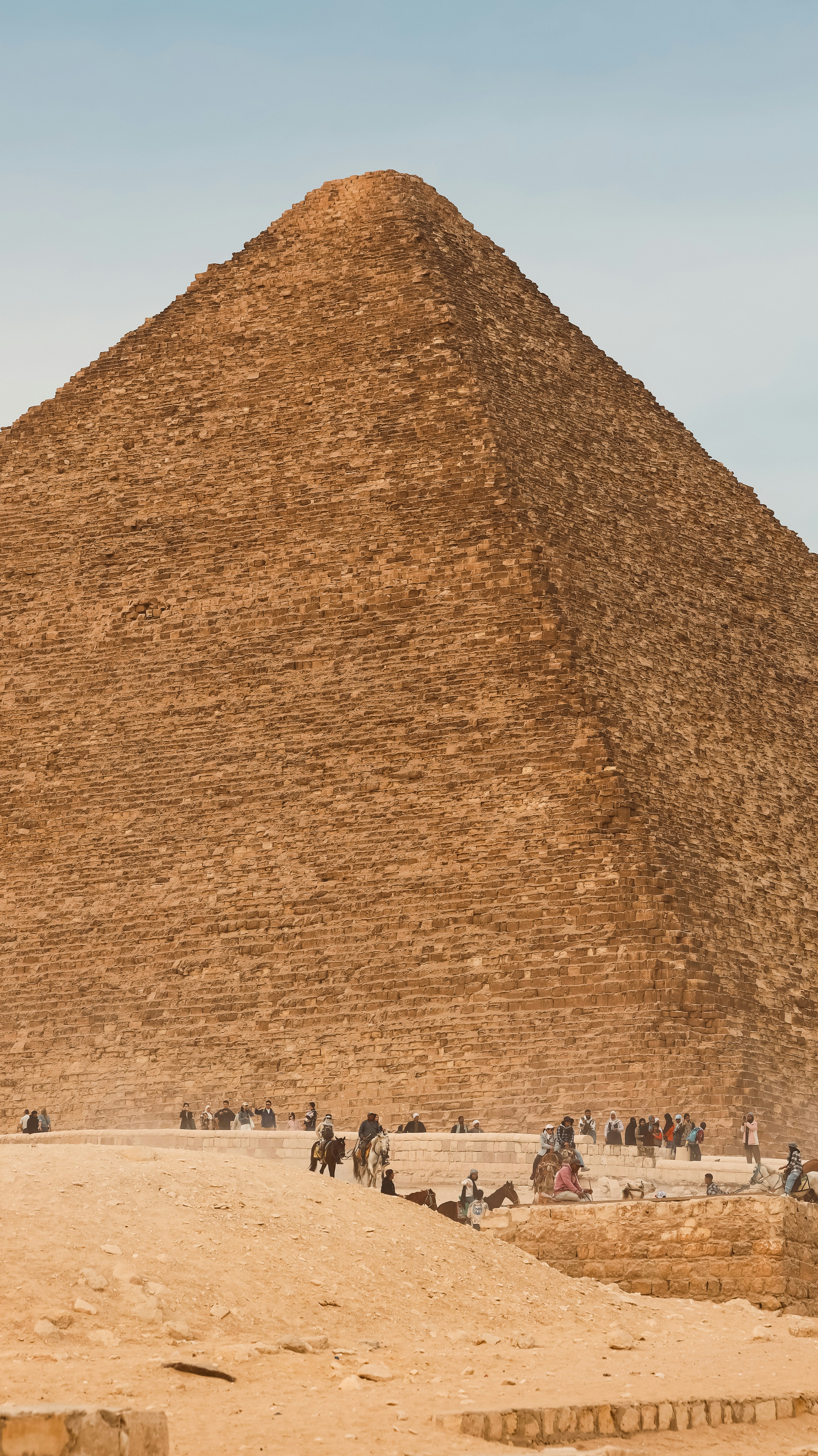 The great pyramid of giza towers over visitors.