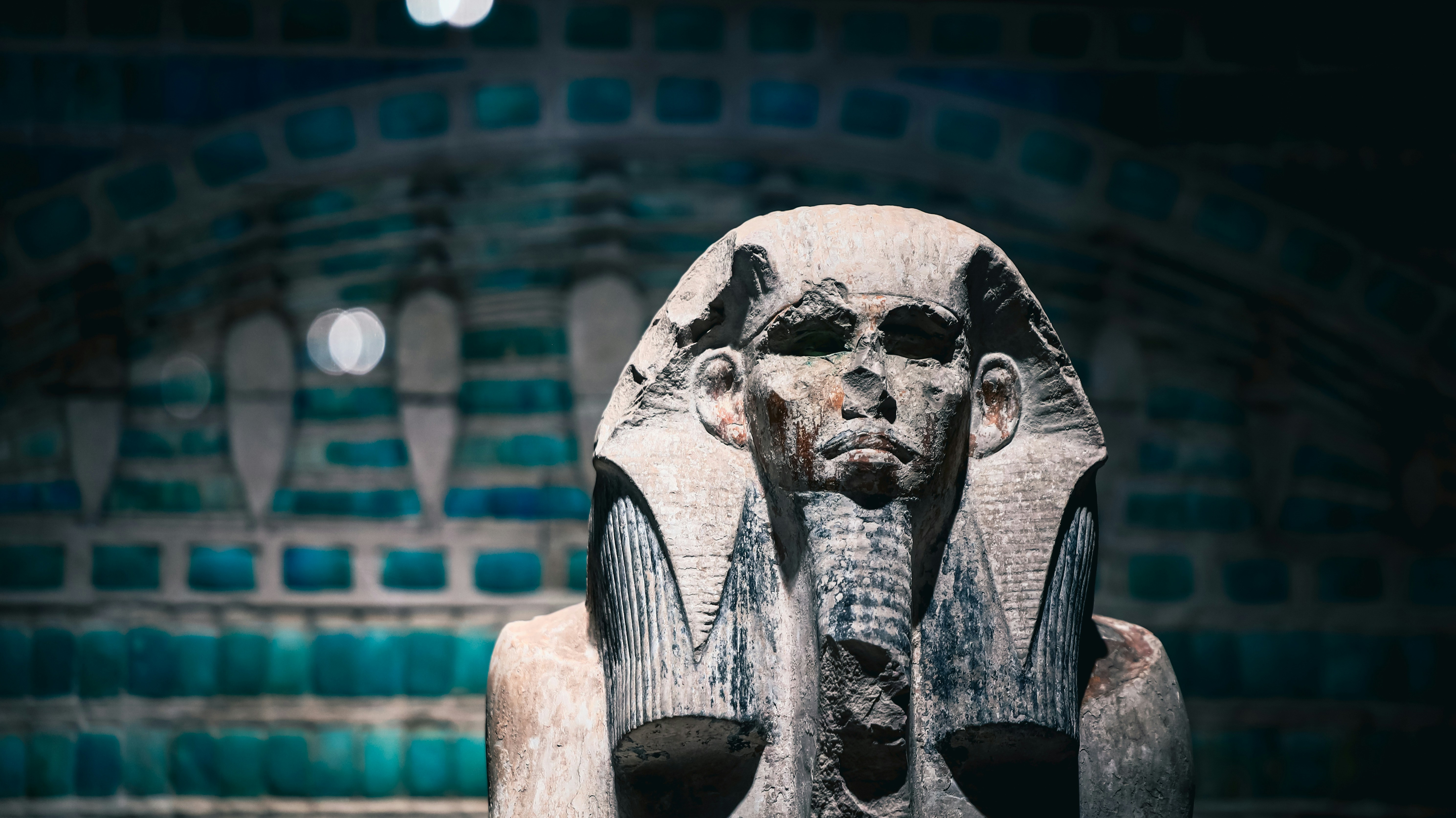 Ancient egyptian pharaoh statue with decorative background.