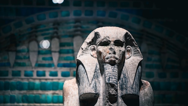 Ancient egyptian pharaoh statue with decorative background.