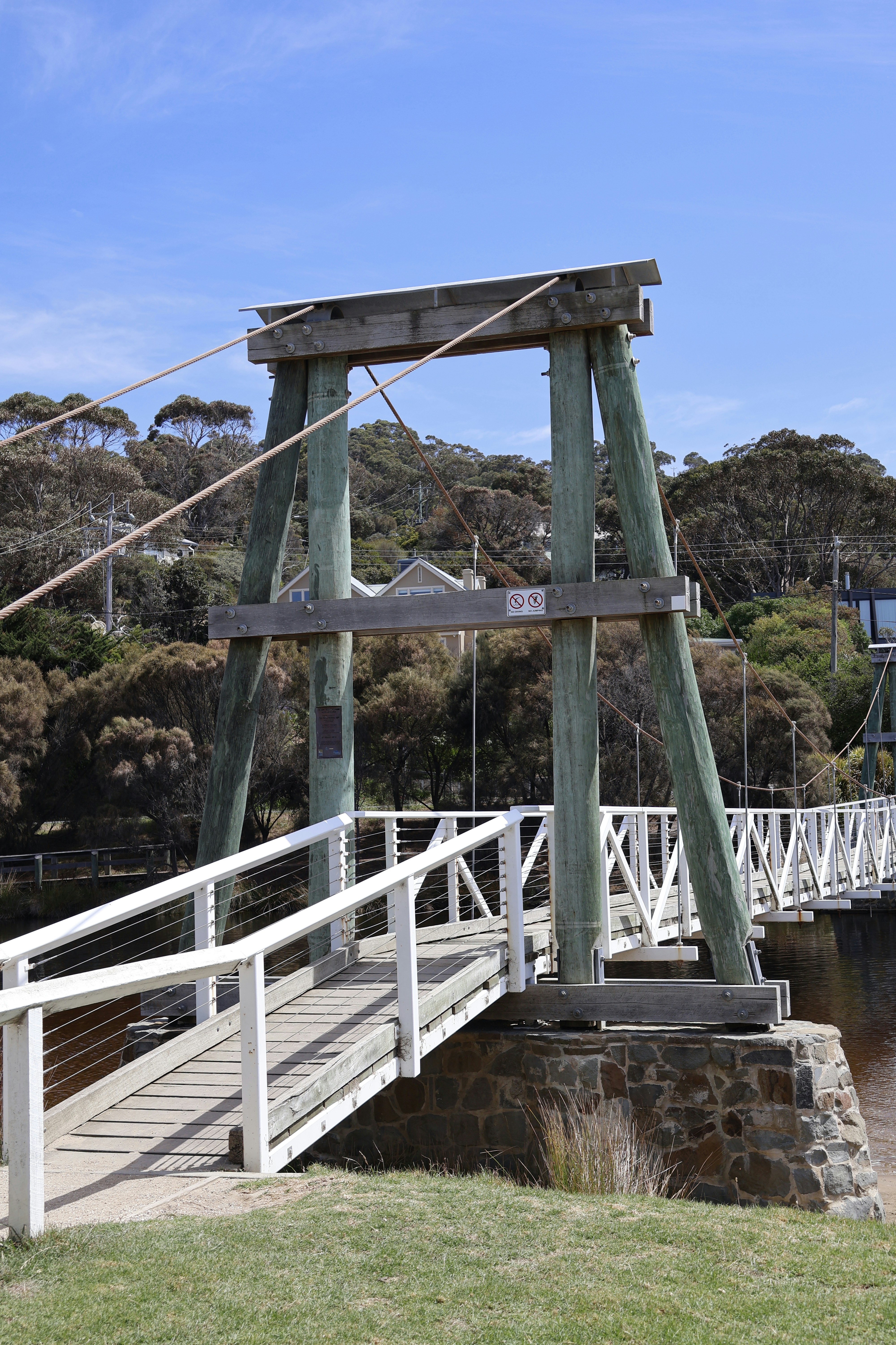 A pedestrian bridge stands under a bright blue sky.
