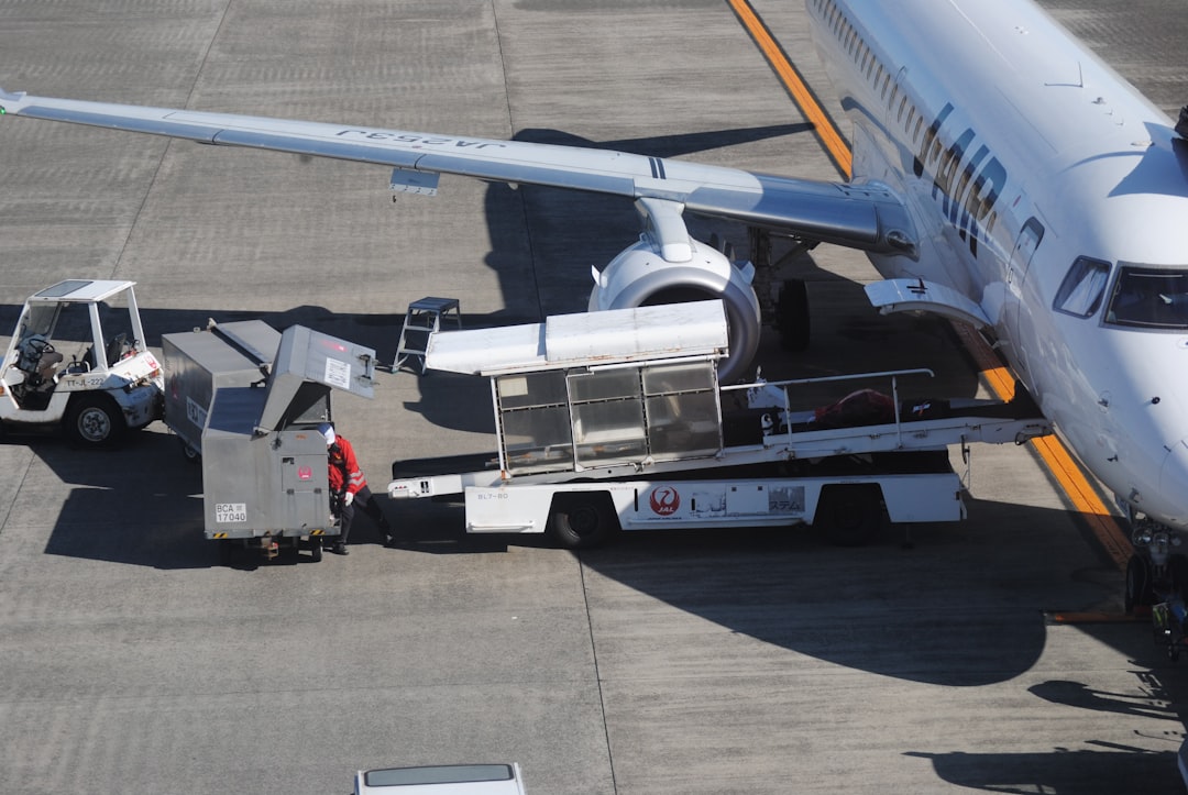 Ground crew loading luggage onto an airplane.,