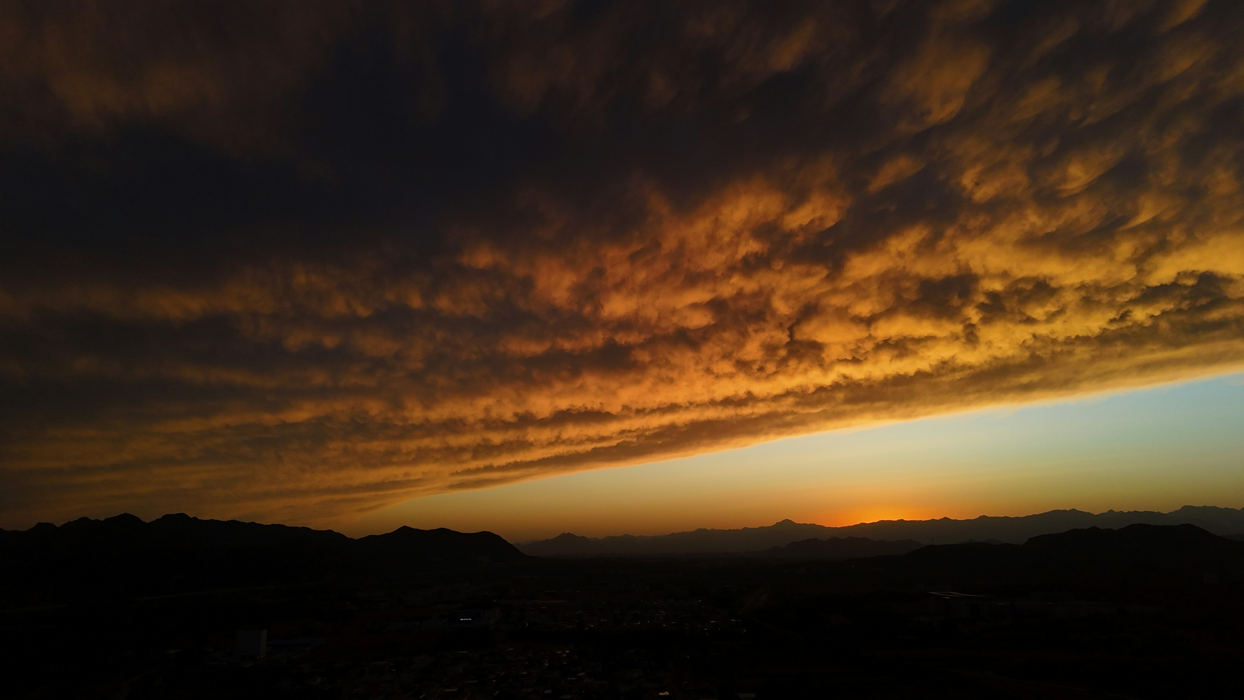 The fiery sunset illuminates the dramatic clouds.