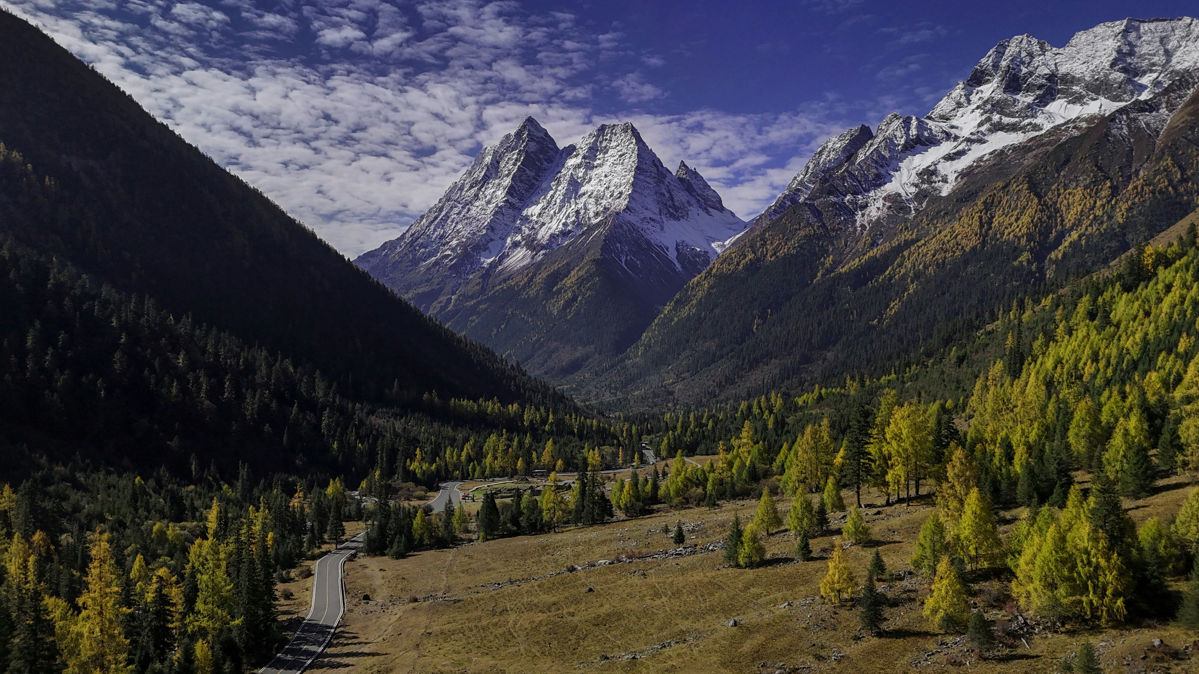 Snow-capped mountains rise over a vibrant landscape.