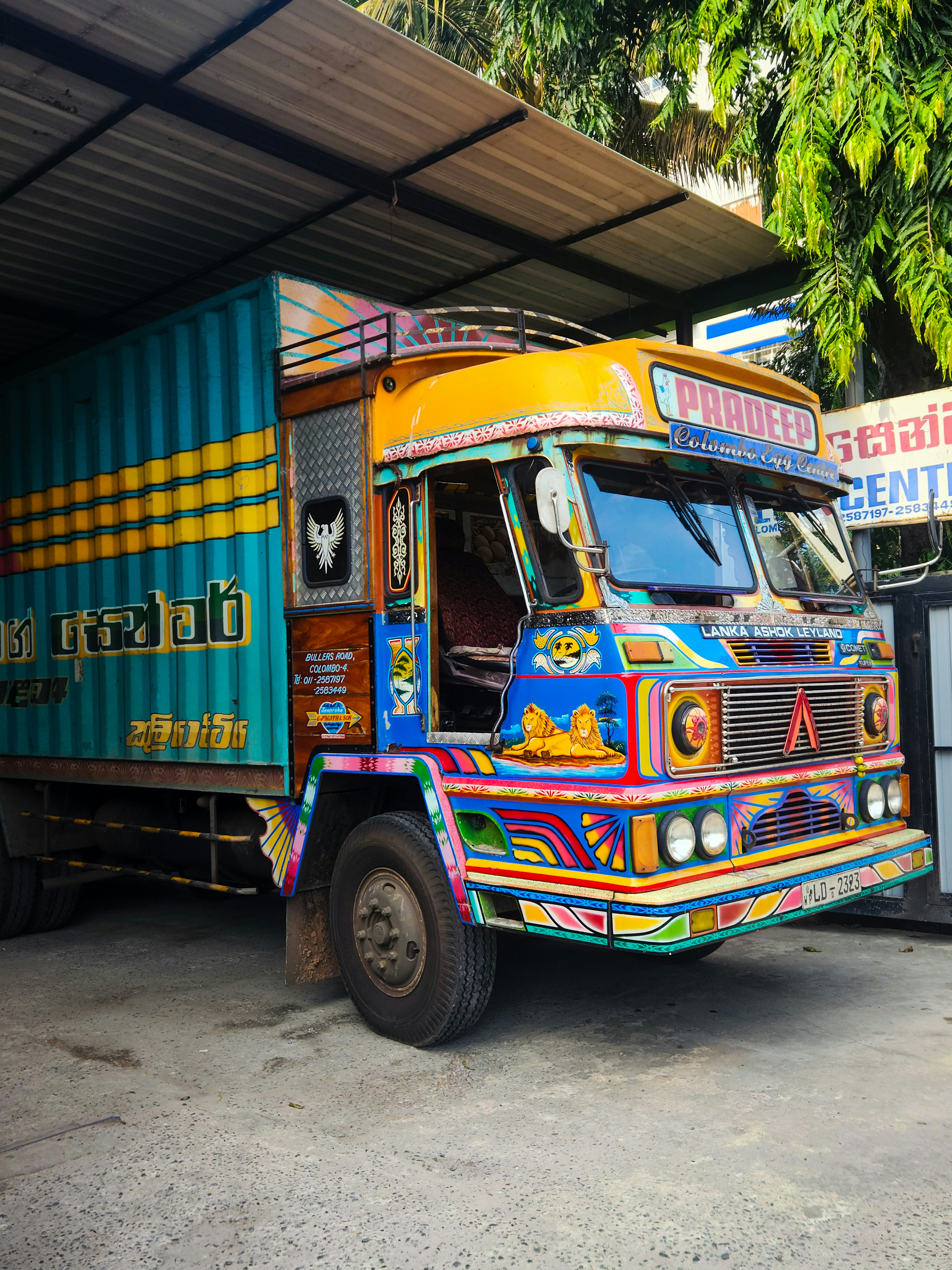 This Lanka Ashok Leyland truck in Colombo, Sri Lanka, showcases traditional South Asian truck art, featuring vibrant colors, intricate patterns, and decorative motifs. The truck's front is adorned with hand-painted designs of lions, floral patterns, and cultural symbols, reflecting the artistic heritage of Sri Lankan transport aesthetics. These uniquely customized trucks are commonly used for cargo transportation across the country.