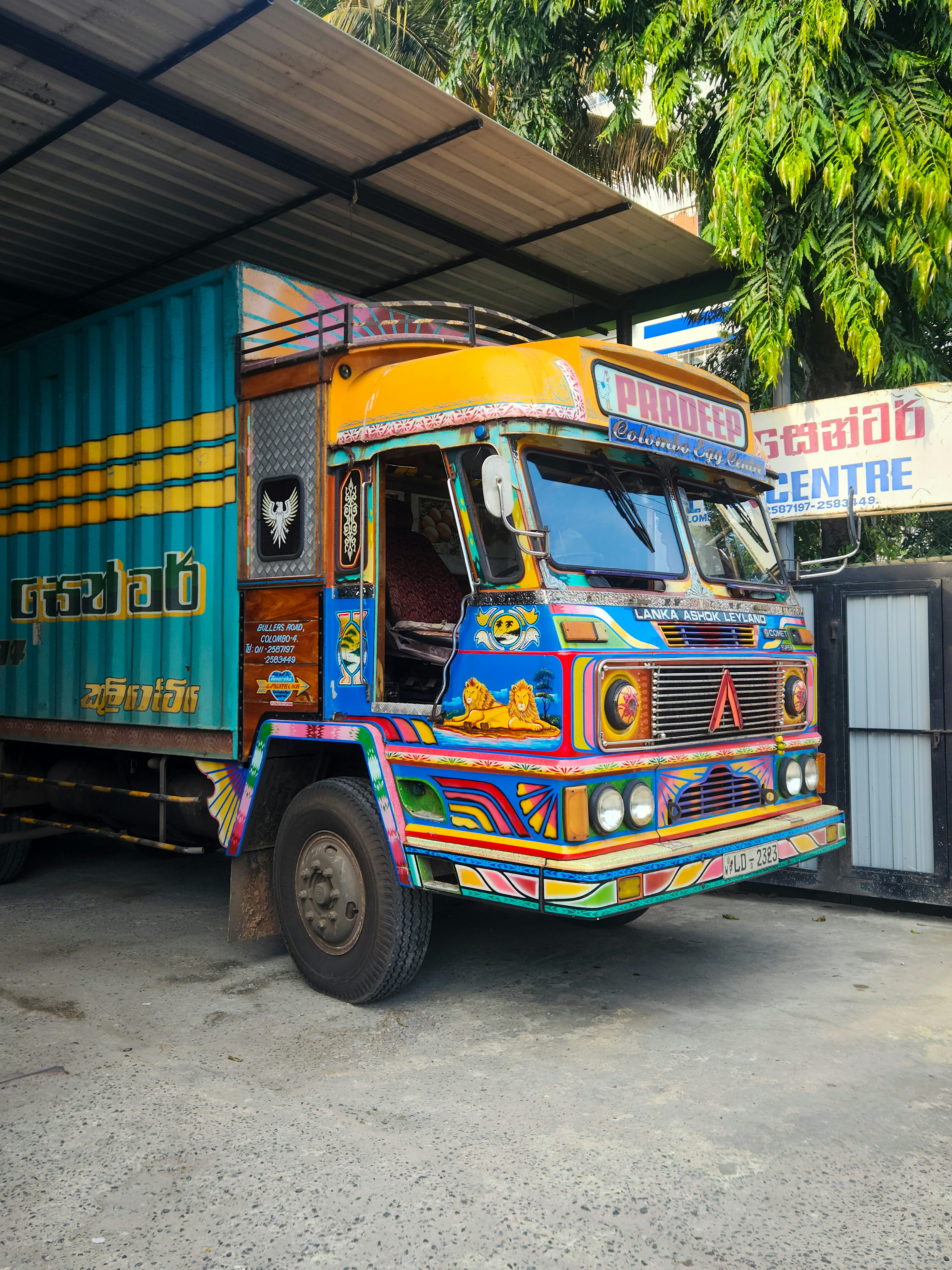 This Lanka Ashok Leyland truck in Colombo, Sri Lanka, showcases traditional South Asian truck art, featuring vibrant colors, intricate patterns, and decorative motifs. The truck's front is adorned with hand-painted designs of lions, floral patterns, and cultural symbols, reflecting the artistic heritage of Sri Lankan transport aesthetics. These uniquely customized trucks are commonly used for cargo transportation across the country.
