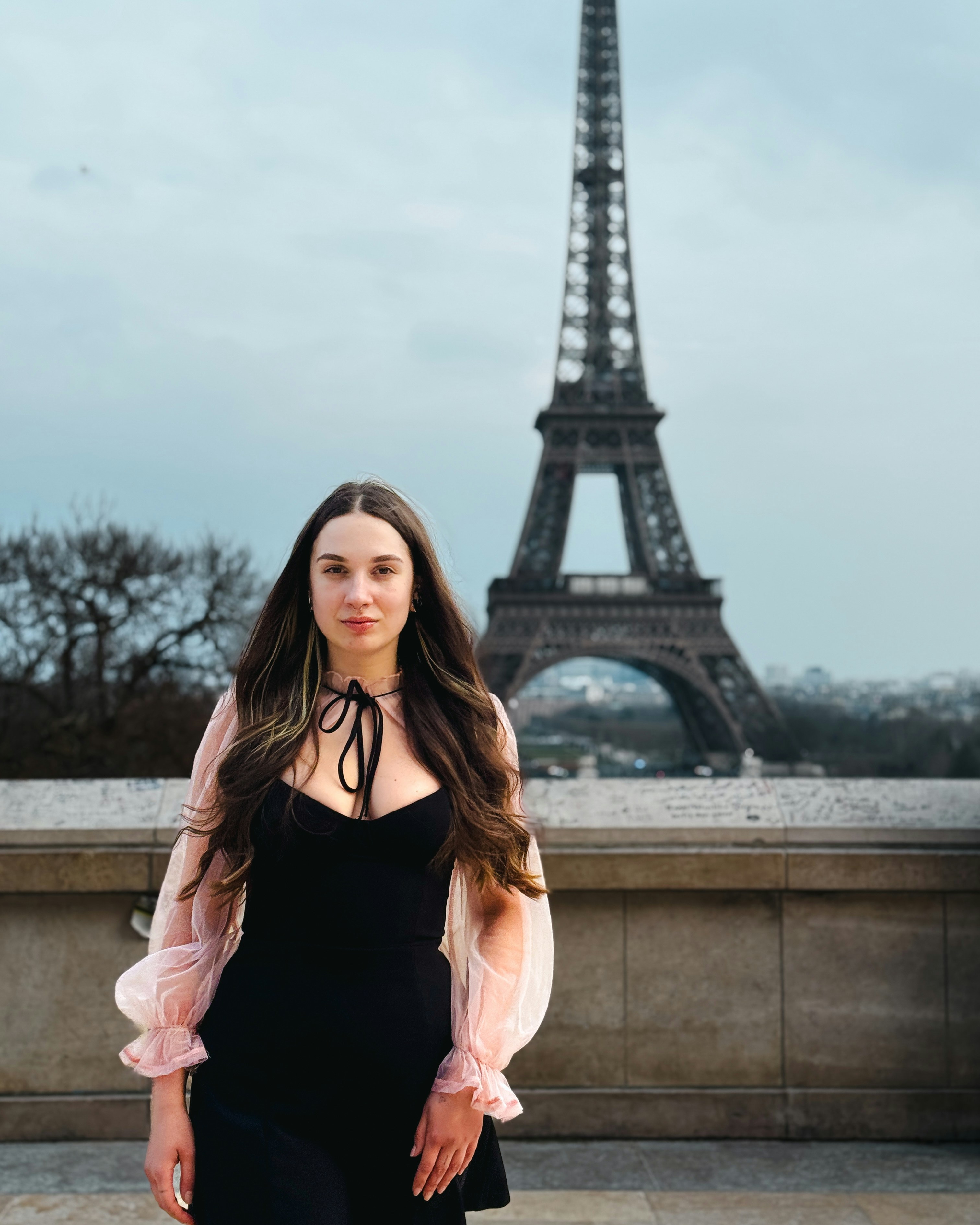 Woman poses in front of the eiffel tower.