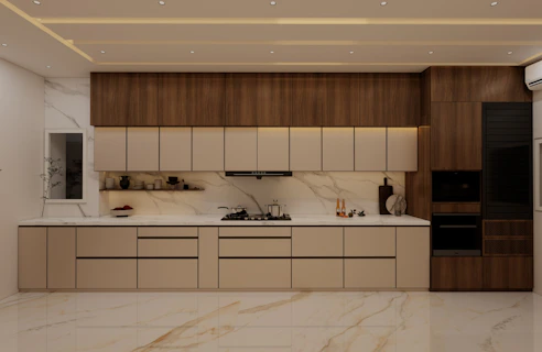 A modern kitchen has sleek cabinets and marble accents.