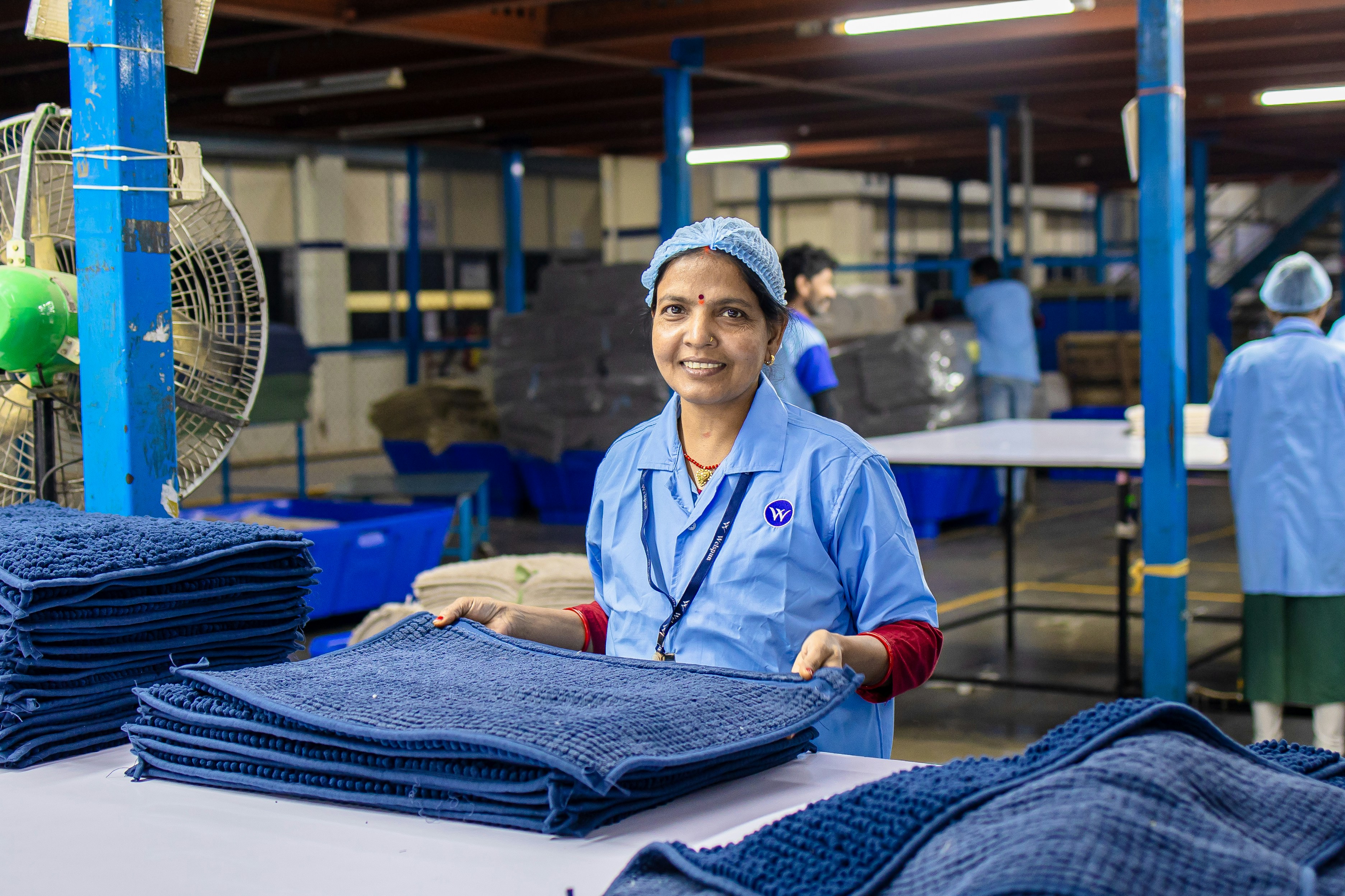 Woman works in factory folding towels
