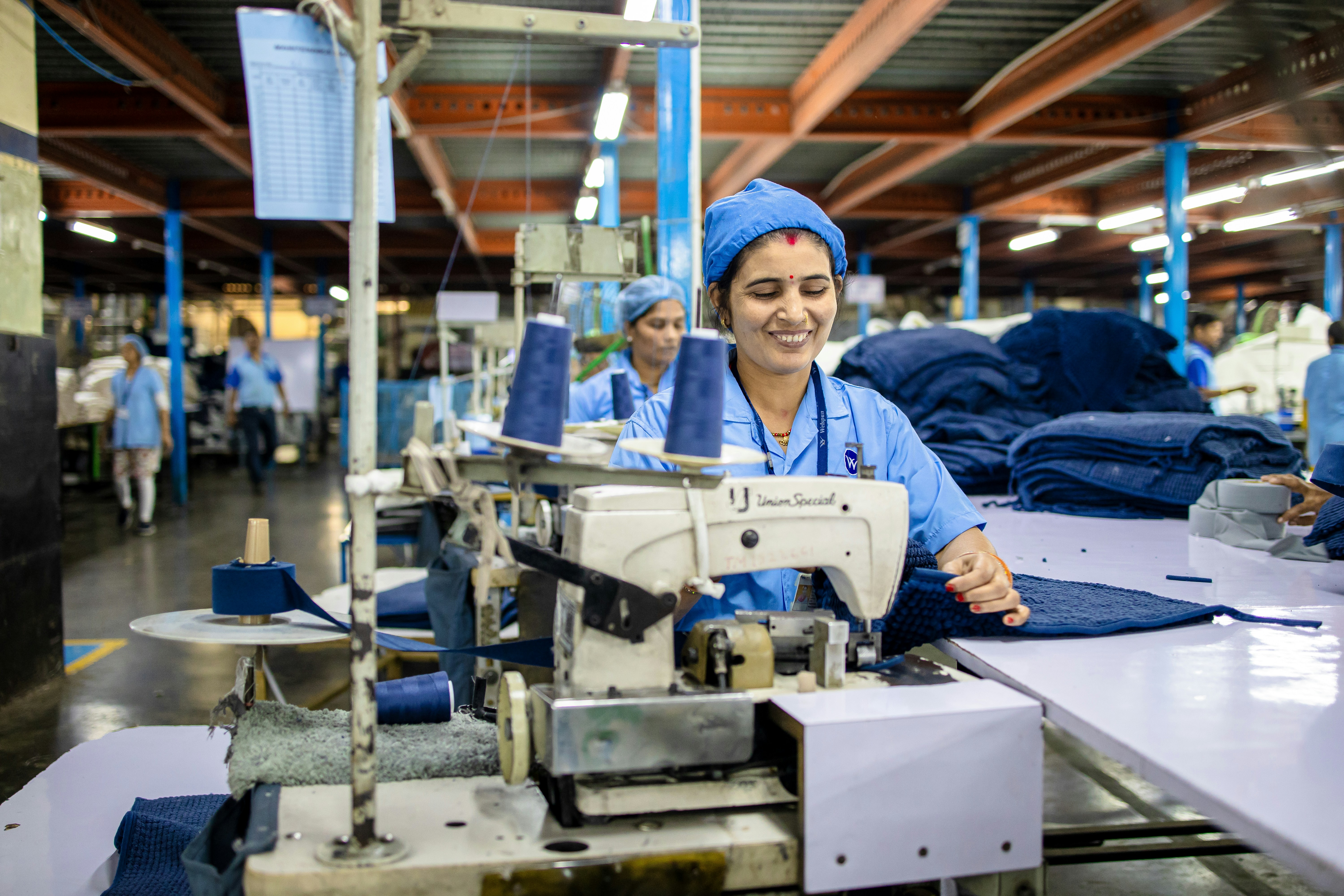 Vue d'ensemble de l'atelier de couture Jinane — plusieurs ouvrières à leurs machines.