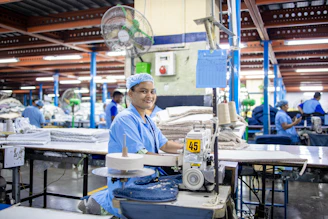 Worker sewing fabric in a textile factory.