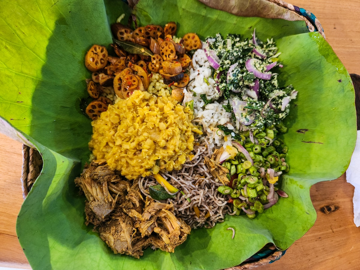 A traditional Sri Lankan rice and curry spread with multiple curries, sambols, and accompaniments served on a banana leaf