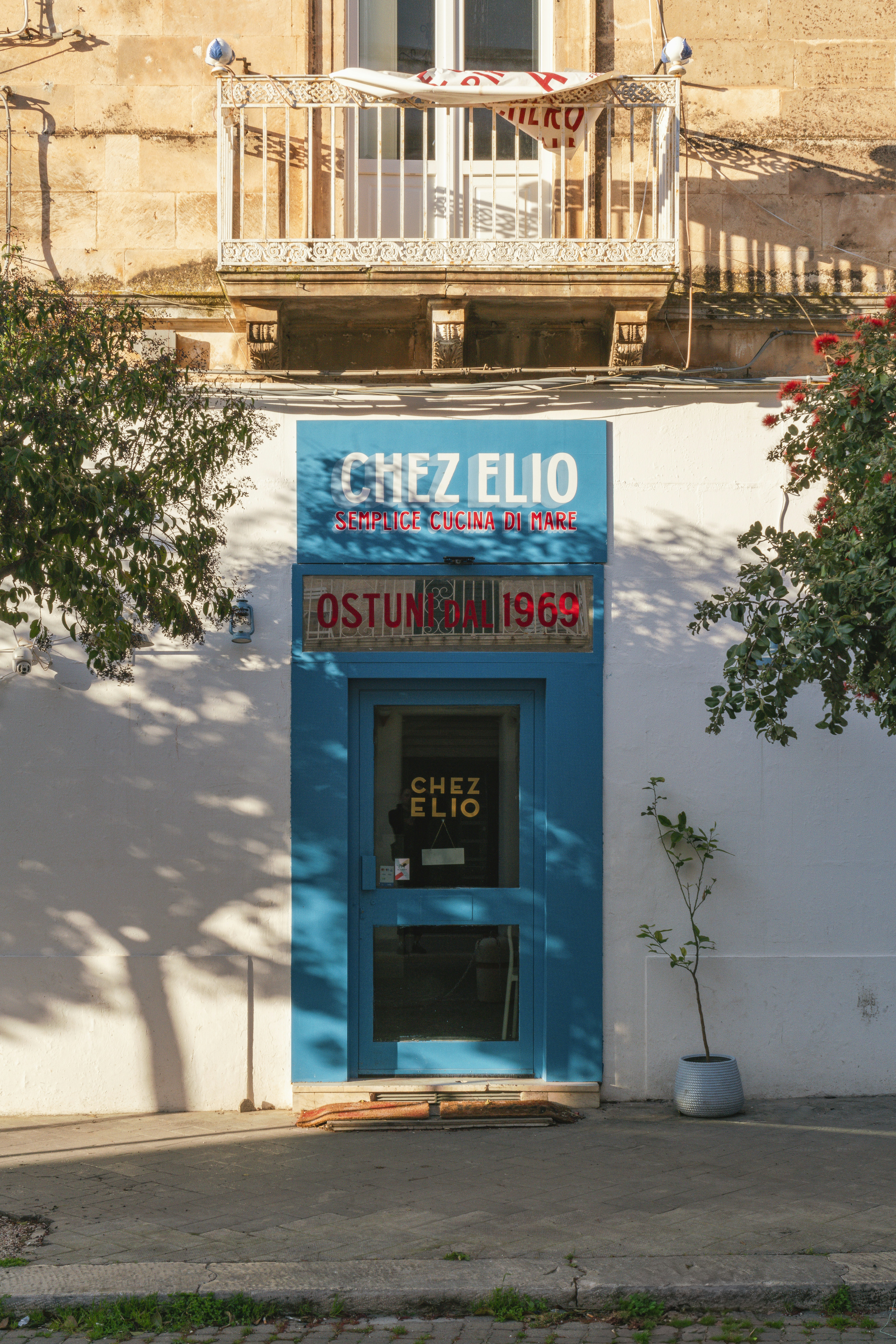 Un ristorante con una porta blu e un'insegna.