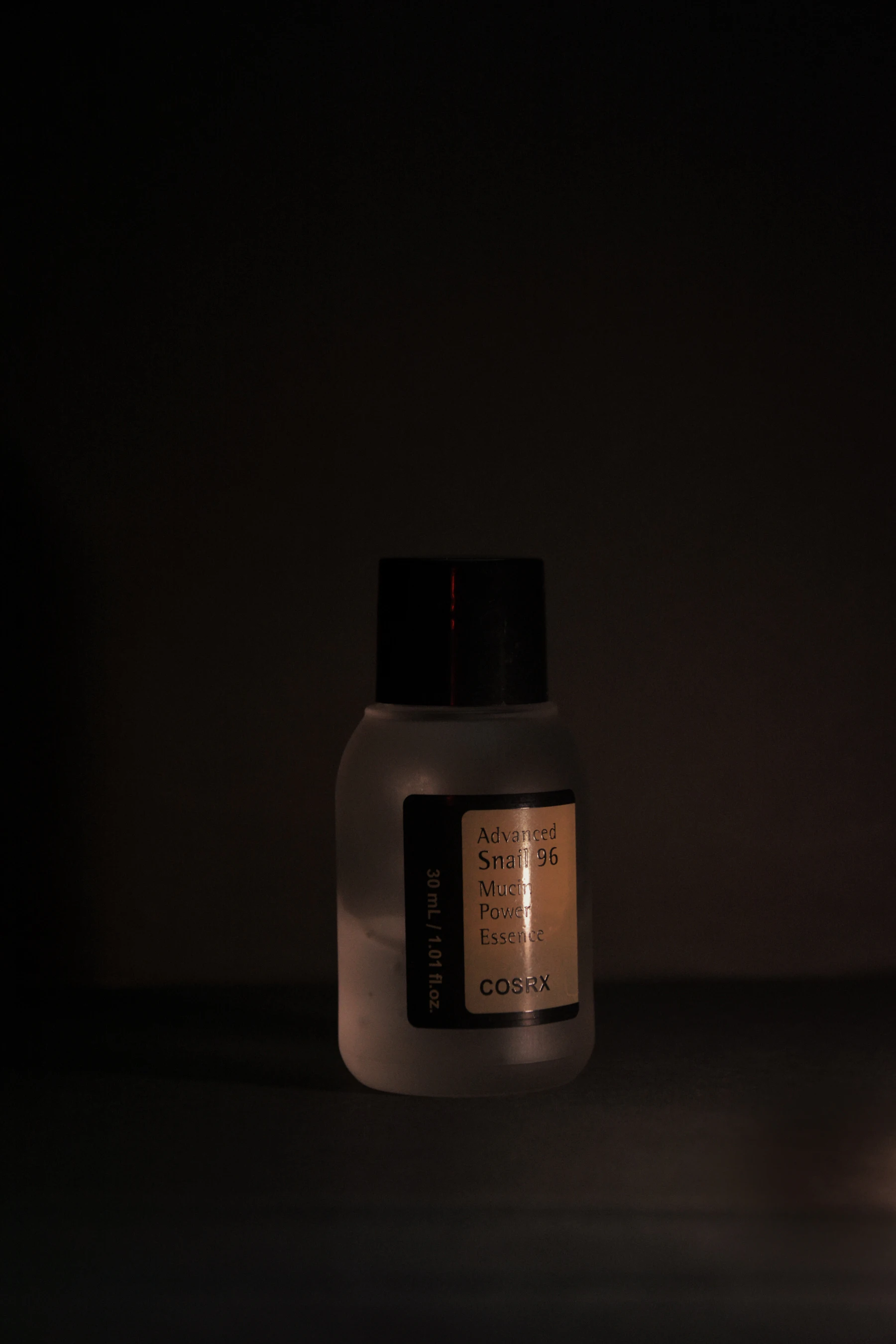 Premium skincare product bottle in dramatic low light