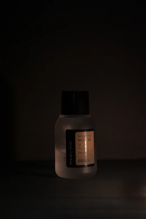Skincare product bottle in a dimly lit setting.