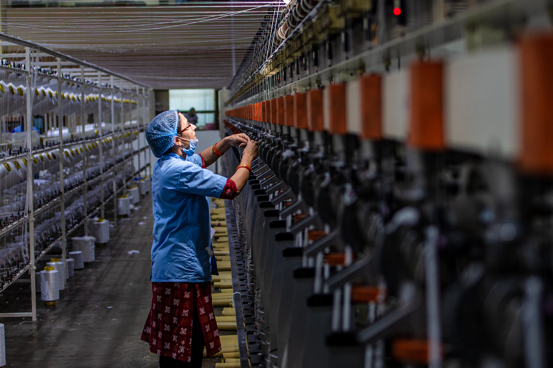 Woman working in a textile factory, operating machines.