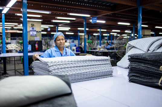 A woman works with textiles in a factory.