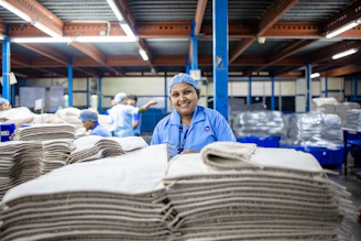 Factory worker smiling at the camera in an industrial setting.