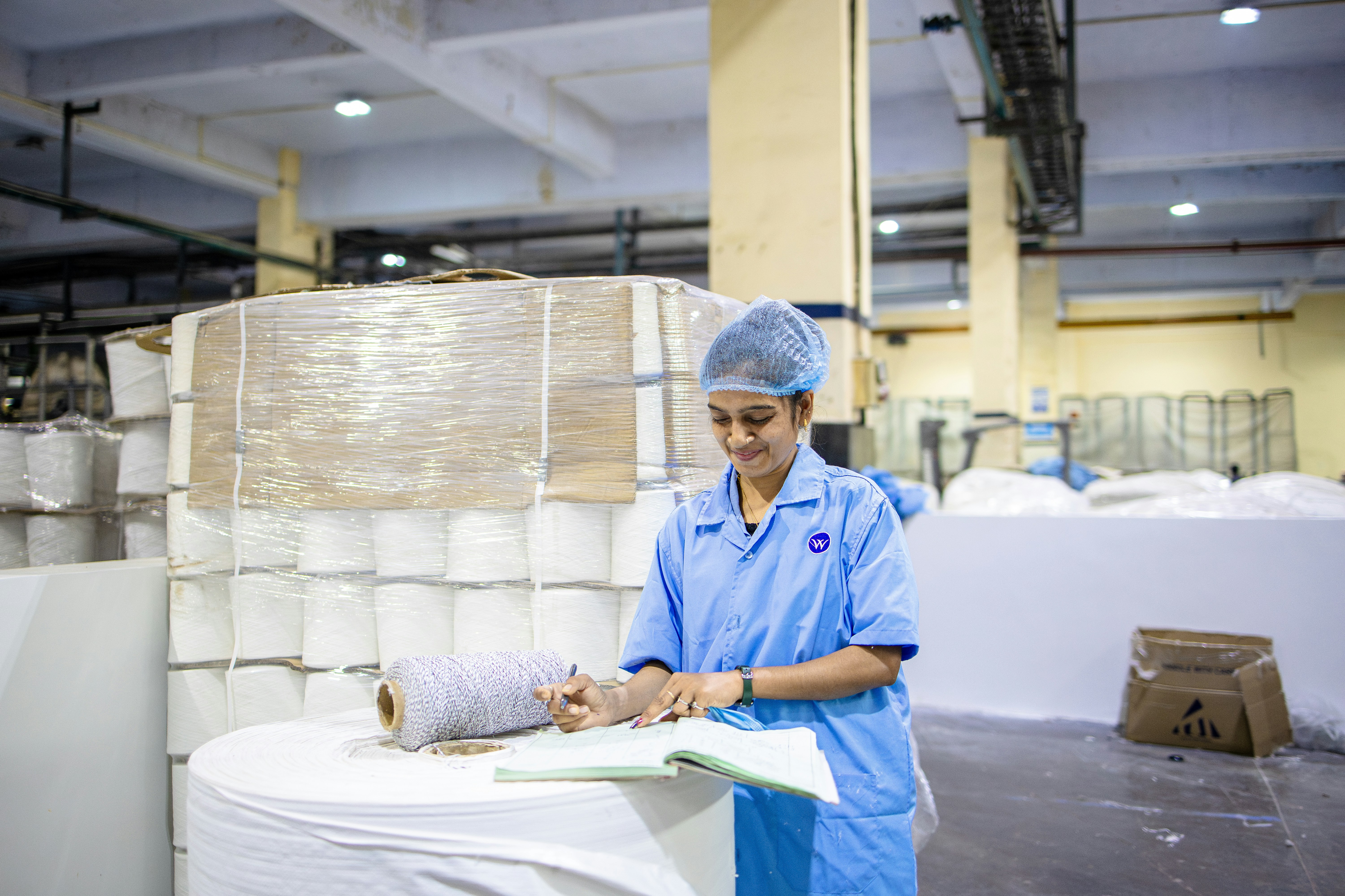 A worker is inspecting materials in a factory.