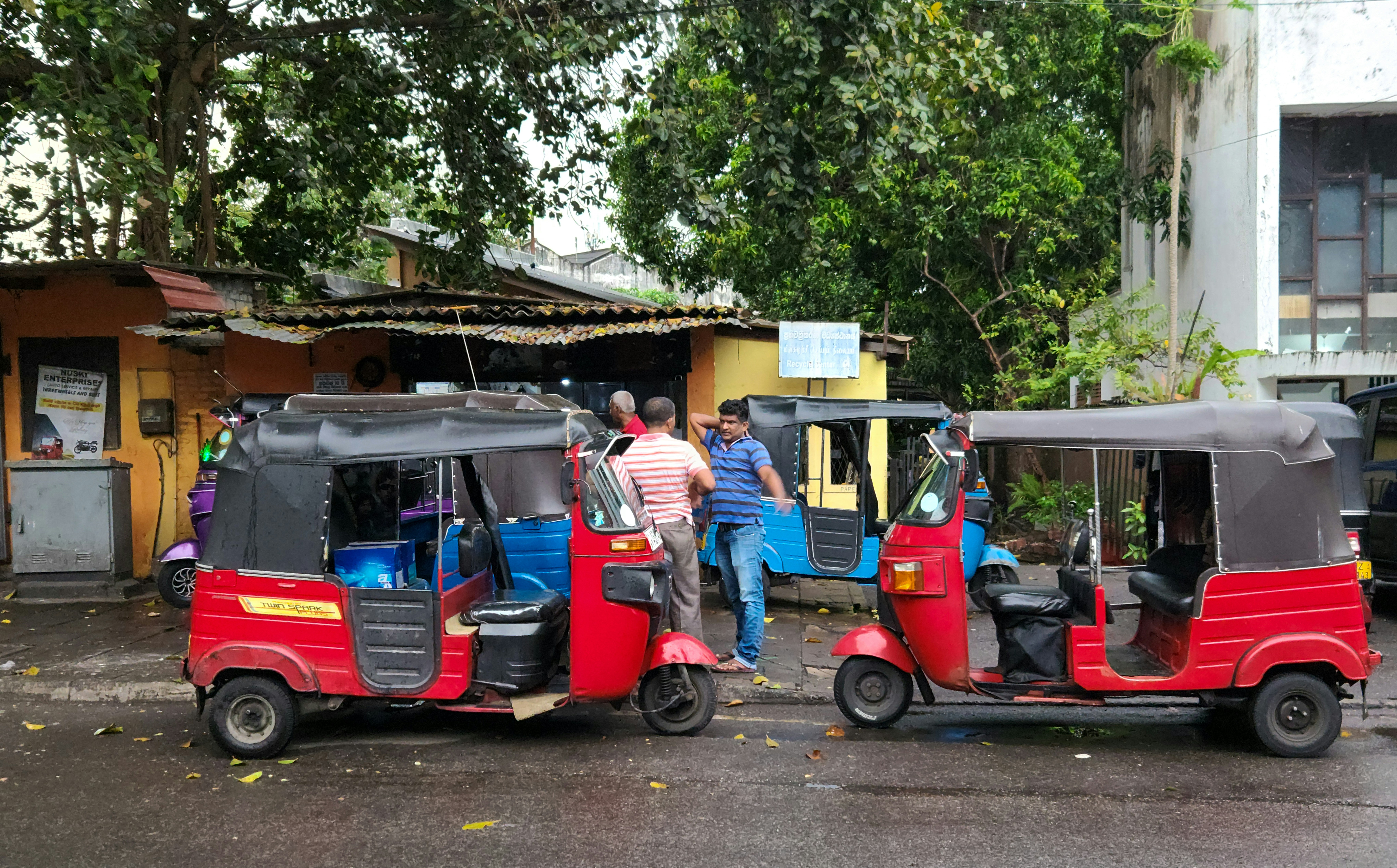 Family standing next to an electric car charging at a public station