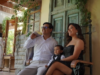 Family posing together outside their home.