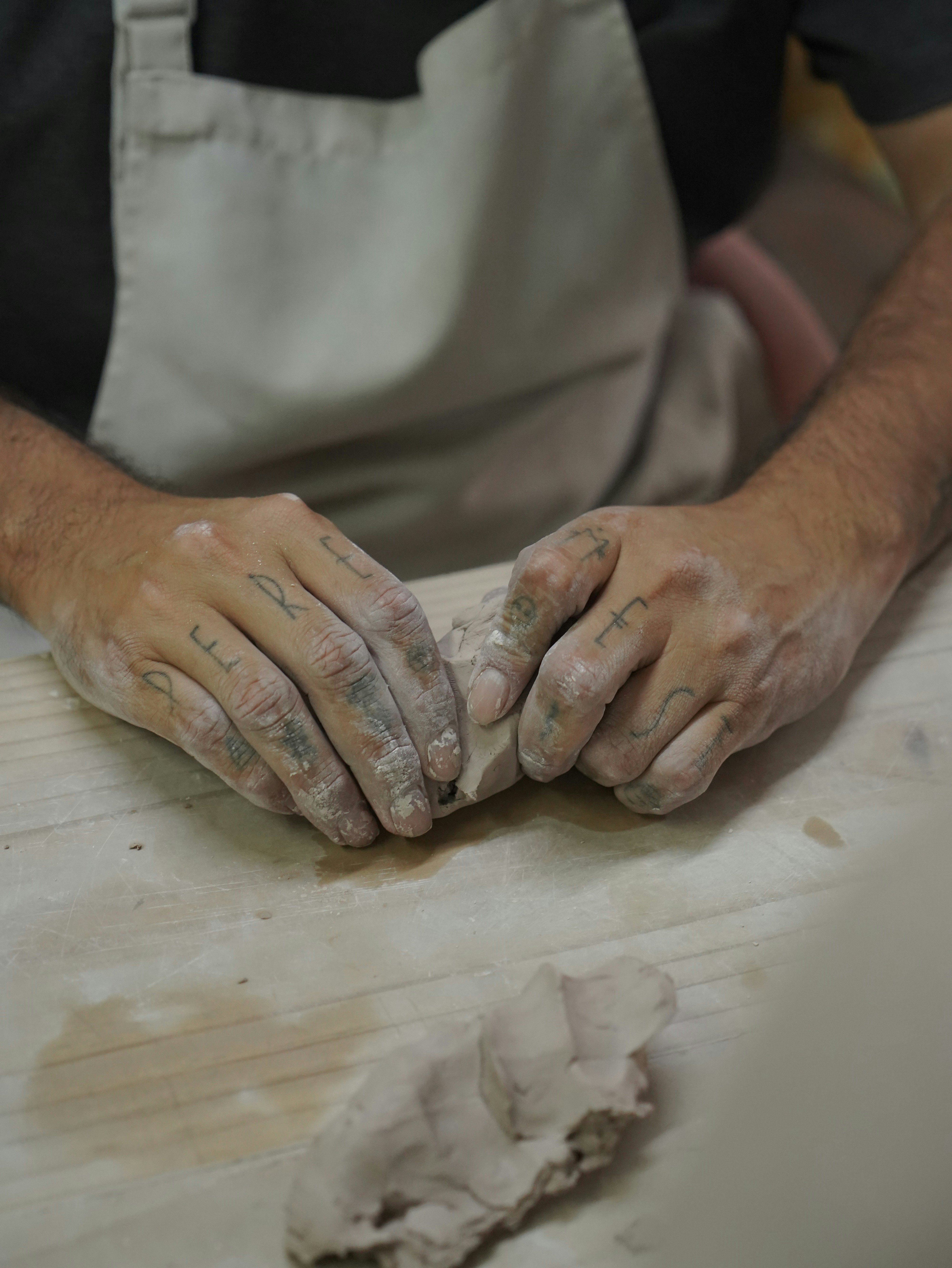 A person is shaping clay with their hands.